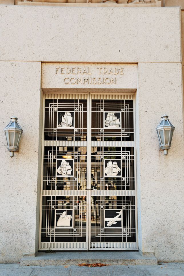 La porte du FTC, qui comporte une porte en métal avec des images sculptées de navires et une place aérienne.