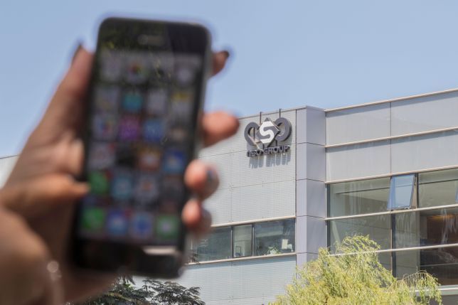 Un iPhone flou est brandi devant NSO Group